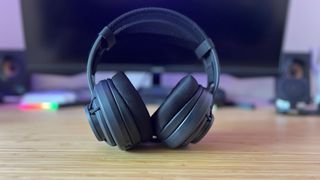 Turtle Beach Atlas Air gaming headset on a wooden desk in front of a PC setup